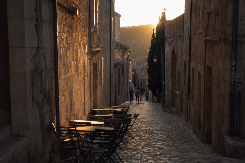 Narrow medieval lane in Saint-Emilion with stone facades and warm light, no text, no logos, no people