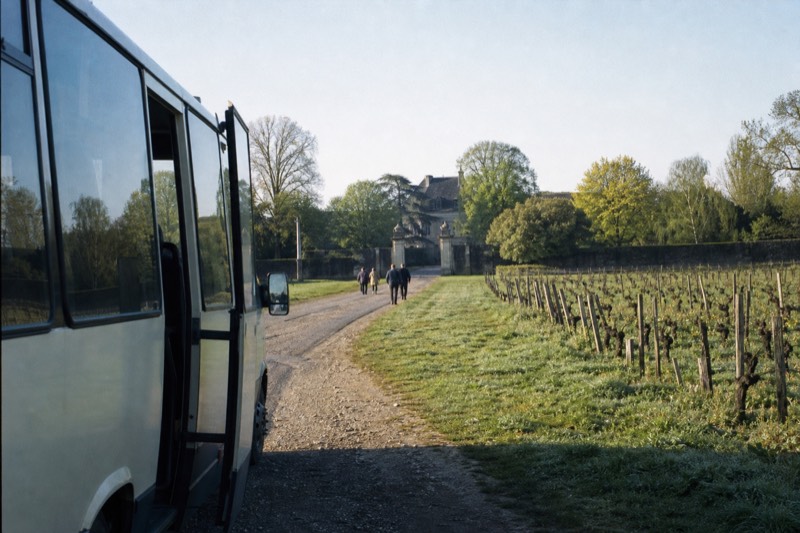 Small minibus parked on a gravel layby along the Saint-Emilion wine road on a bright spring morning