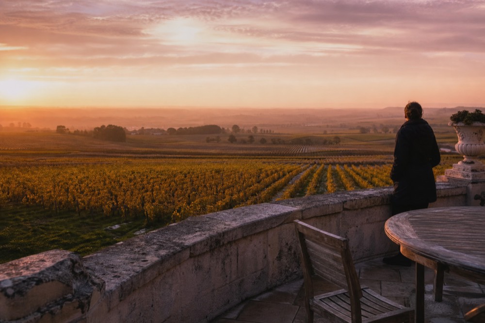 Limestone terrace overlooking vineyards outside Saint-Emilion village at golden hour, no text, no logos, no people