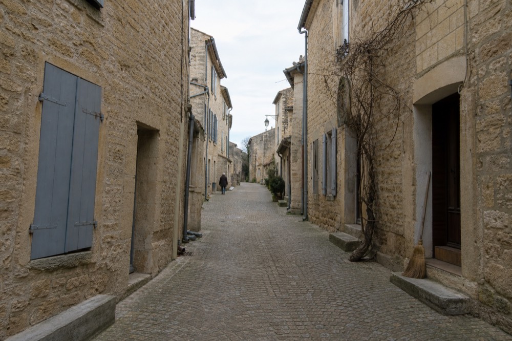 Cobblestone street in Saint-Emilion village with stone buildings and shutters, no text, no logos, no people