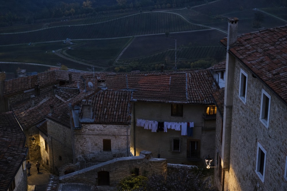 View over red-tiled roofs of Saint-Emilion toward vineyards at dusk, no text, no logos, no people