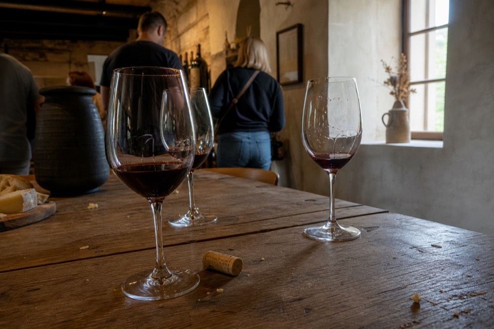 Tasting room with glasses of red wine poured on a wooden table, no text, no logos, no people